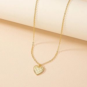 Elegant gold heart pendant necklace with quilted texture on a minimalist O-chain