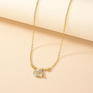 Collier élégant pendentif Saturne en or avec diamants étincelants sur surface beige