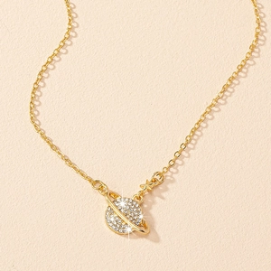 Vue macro d'un collier pendentif planète dorée avec cristaux et détail d'étoile