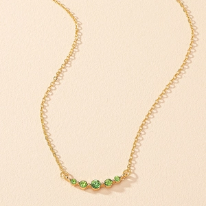 Macro detail of French vintage gold necklace featuring five graduated green zircon stones