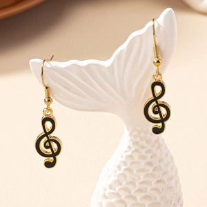 Detailed view of musical note earrings featuring gold edges and black enamel finish