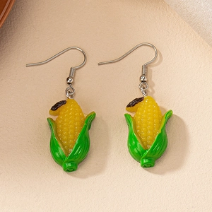 Vue détaillée de boucles d'oreilles maïs réalistes en résine avec grains jaunes et feuilles