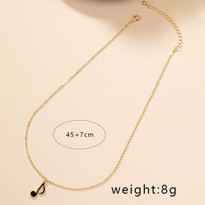 Détail du collier chaîne dorée 45+7cm avec pendentif note de musique en émail noir