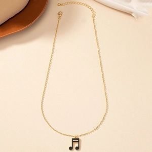 Détail du pendentif note de musique dorée avec émail noir et chaîne réglable
