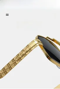 Macro shot of gold engraved temples and hinges on luxury driving sunglasses