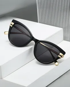 Chic cat eye sunglasses with gold accents on a minimalist white geometric display