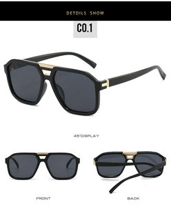 Detail view of oversized pilot sunglasses with black frame and gold metal striped accents