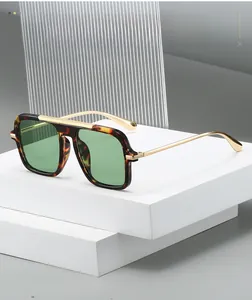 Close-up of square tortoiseshell sunglasses with light green lenses on white stone blocks