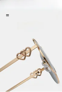 Macro detail of golden metal temples featuring elegant hollowed-out double heart design