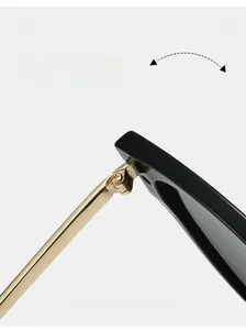 Close-up of durable metal hinge on black cat-eye sunglasses with gold metal temples