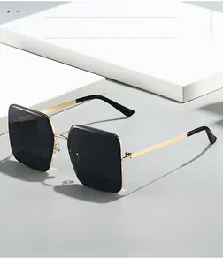 Detail view of square metal frame sunglasses with dark lenses on a minimalist white pedestal