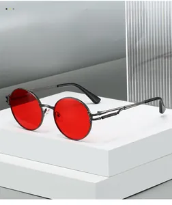 Detail shot of vintage round metal sunglasses with red lenses and spring hinges on stand