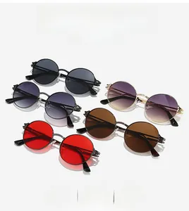 Close-up of retro round metal sunglasses with detailed engraving on temples and nose bridge