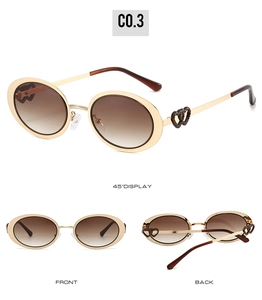 Detail view of oval sunglasses with gold metal frame and heart-shaped hollow temple design
