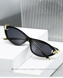 Close-up of cat eye sunglasses featuring thick gold chain link hinges on black frames