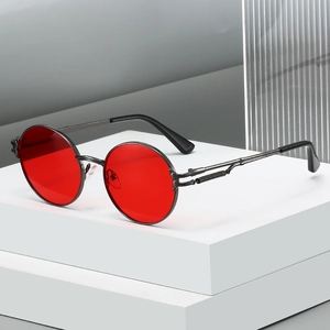 Retro steampunk round sunglasses with red lenses and gunmetal spring temples on a white pedestal