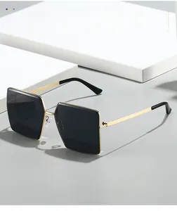 Close-up of rimless square sunglasses featuring gold metal frames and dark lenses