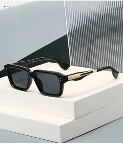 Detail shot of black square frame sunglasses featuring gold metal decorative temples