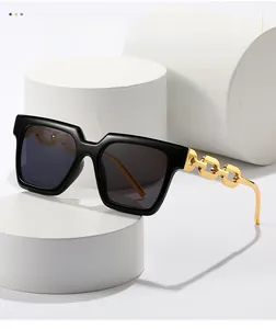 Detail of black square frame sunglasses with golden metal chain-link temples on a white base