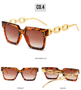 Detail view of tortoiseshell square sunglasses with gold chain temples and gradient lenses