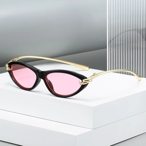 Cat eye sunglasses with pink lenses, black and red frame, and gold knot metal temples