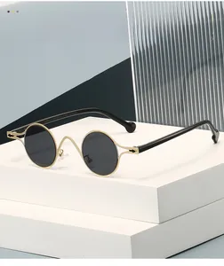 Macro detail of oval dark lenses with gold metal frames and minimalist curved bridge