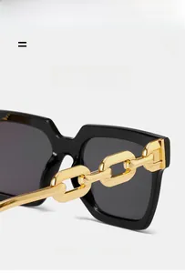Macro detail of black square sunglasses featuring a stylish chunky gold chain temple design