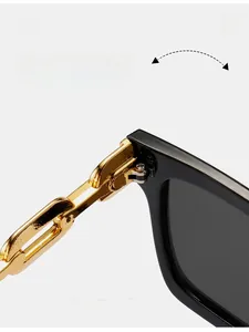 Detailed macro view of robust gold metal hinges and chain-link arm on black sunglasses