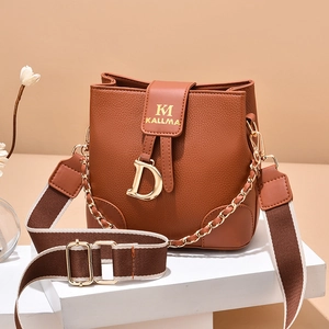 Brown litchi leather bucket bag with gold chain, wide canvas strap, and D charm