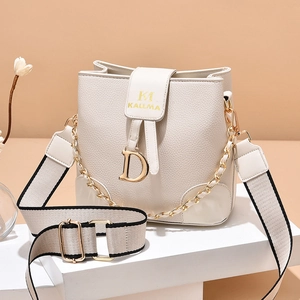 Elegant off-white bucket bag with large D hardware and wide woven strap on display