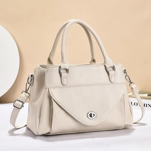 Detail van crème handtas met lychee-textuur leer met zilveren sluiting en afneembare riem