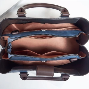 Innenansicht der großen Ledertasche mit Fächern und champagnerfarbenem Satinfutter