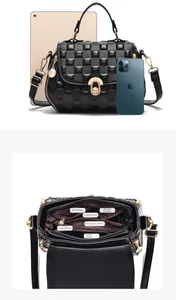 Detail der geprägten Damenhandtasche mit Gold-Drehverschluss und organisierter Innenaufteilung
