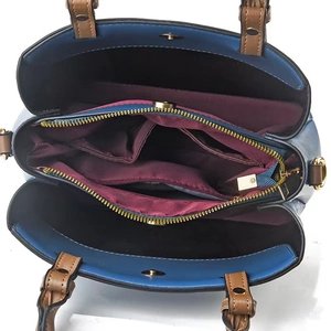 Detailed interior view of checkered shoulder bag with multiple compartments and gold hardware