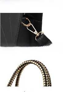 Detail of black textured leather bag with gold metal V hardware and braided handle