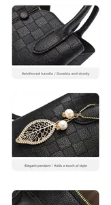 Close-up of reinforced handles and pearl leaf charm on black textured leather bag