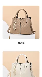 Detail of khaki textured checkered tote bag with metal leaf and pearl charm on a pedestal