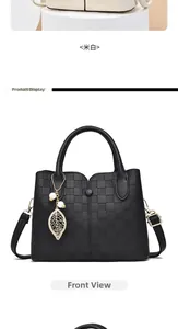 Detail of checkered embossed leather bag with golden leaf pendant and pearl charm