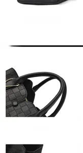 Detail of checkered embossed leather texture and sturdy handles on the black tote bag