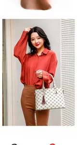 Close-up of white checkered tote bag with brown leather tassel and elegant handle