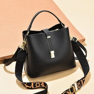 Elegant black lychee leather bucket bag with gold hardware and geometric woven strap