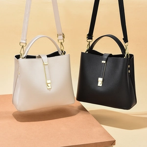Minimalist faux leather bucket bag with gold hardware in cream and black colors