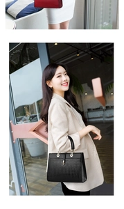 Detail of black tote bag featuring woven texture design and golden metal lock buckle