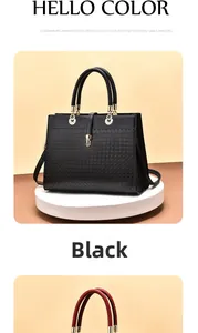 Detail of black leather tote bag featuring woven texture and gold metal ring handle
