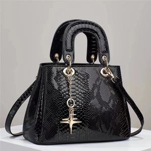 Elegante zwarte handtas met slangenpatroon, gouden ster hanger en handvatten