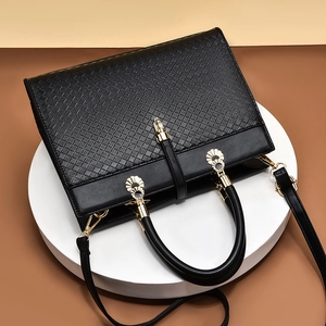 Elegant black crossbody bag with woven texture, smooth leather and gold hardware