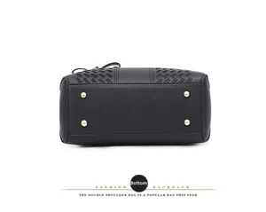 Vue du fond du sac en cuir noir avec pieds de protection dorés et détails tissés fins