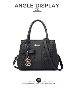 Vue de face sac à main noir en cuir avec nœud et pendentif cœur doré chic