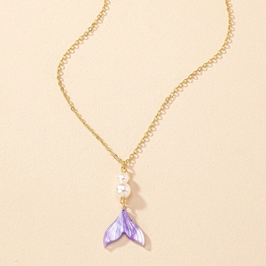 Macro detail of the golden chain with two white pearls and a purple mermaid tail pendant