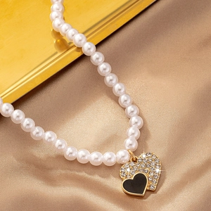 Collier de perles de luxe avec pendentif double cœur sur fond de soie champagne